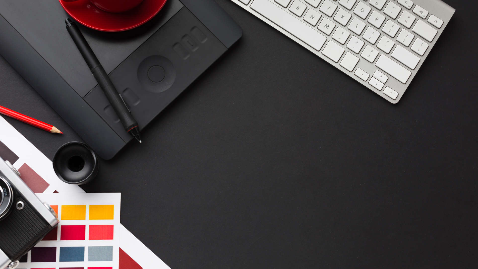 Designer workspace with tablet, keyboard, and color swatches